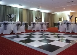 blackand white dancefloor white chaircovers black sash and feathers at portsmouth marriott